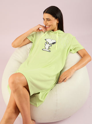 a women seat on couch and weared green lily half sleeve short dress
