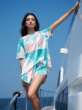 a women standing on a boat wearing a malibu abstract half sleeve shorts set