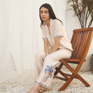 A women setting on wooden chair wearing pyjama set