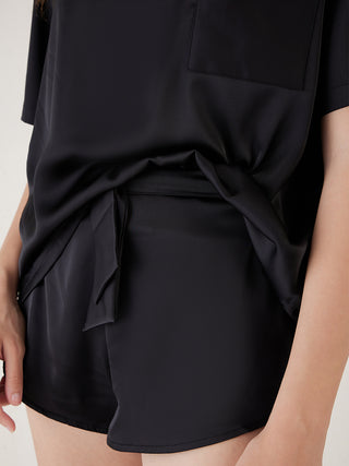 a woman wearing black color silky shorts set