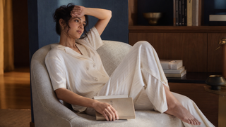 Synthetic South Asian woman in Sweet Dreams star-white stripe palazzo set reclining in a dawn-blue library alcove at first light