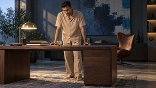 Synthetic Indian man in dune Sweet Dreams pyjamas looking at an alarm clock in an early-morning study