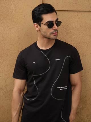 Men wearing a black t-shirt with abstract grey lines and white text, posing with a slight head tilt and looking away from the camera.