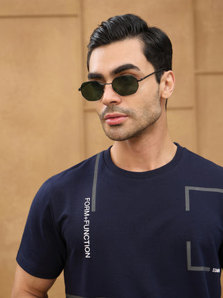 Men wearing a navy t-shirt with "FORM+FUNCTION" printed vertically on the front and geometric gray accents, also has sunglasses on.
