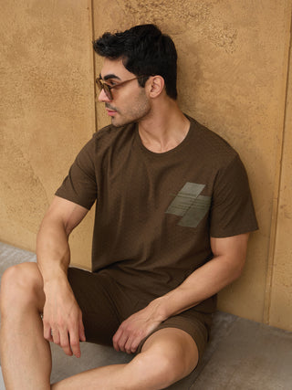 Men lounging in a short-sleeved, brown, printed t-shirt and matching shorts.