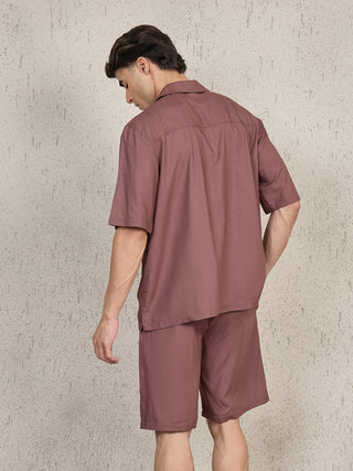 Men wearing a brown short-sleeved collared shirt and matching shorts, posing with back to the camera.