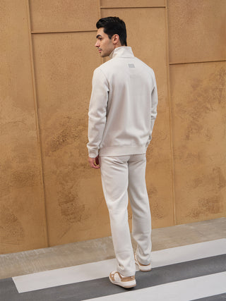 Men's light beige tracksuit, standing with back to camera.