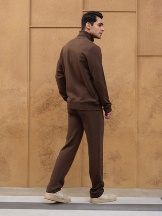 Men in a full brown tracksuit pose turned away from the camera.