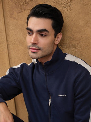 Men wearing a navy blue tracksuit with white stripes and a zipper.