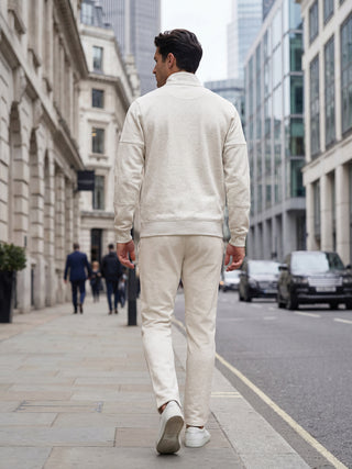 Men's light beige tracksuit, walking outdoors, showing the back view.