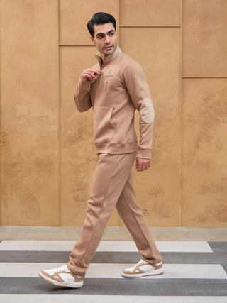 Men walking in a light brown zippered sweatshirt and matching pants.