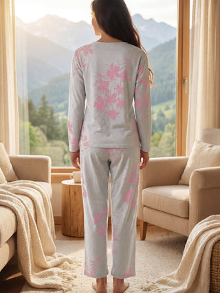 Women in a light gray long-sleeved pajama set with a pink floral print, standing with their back to the camera.