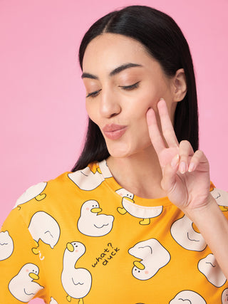 Women in a yellow t-shirt with a duck print, pouting and holding two fingers up to her cheek.
