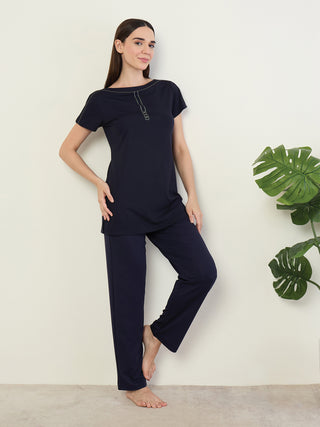 A woman poses in a navy blue pajama set.