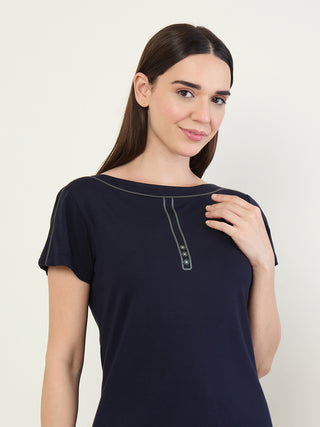 A woman is posing in a navy blue sleep shirt with a V-neck and short sleeves.
