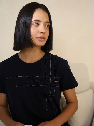 A woman in a navy blue t-shirt with a dashed line and star print.