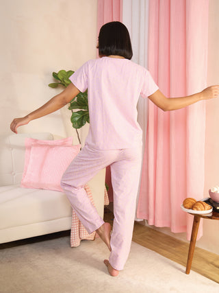 Women performing a yoga pose in light pink patterned sleepwear.