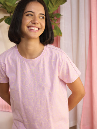 A woman in a pink floral pajama shirt is shown from the waist up.