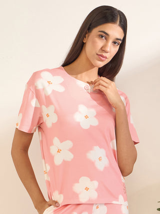 Women in a frontal pose wearing a pink floral print sleepwear t-shirt.