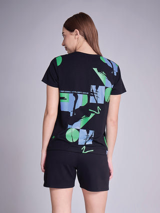 Women, viewed from the back, wearing a black t-shirt with a geometric and abstract print and black shorts.