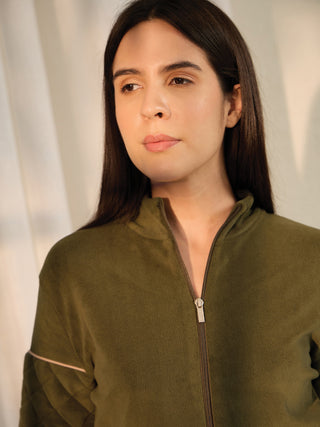 A woman in a green zippered fleece jacket with pink trim and a quilted pattern.