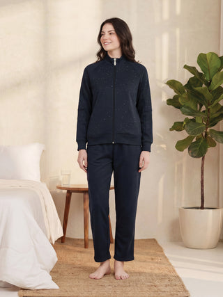 A woman poses in a navy blue tracksuit with a dotted print.