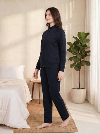 A woman poses in a navy blue pyjama set with a subtle sparkle print.