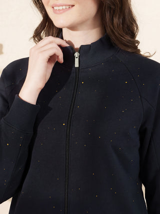 Women wearing a navy blue zip-up jacket with a star print, with her hand near the collar.