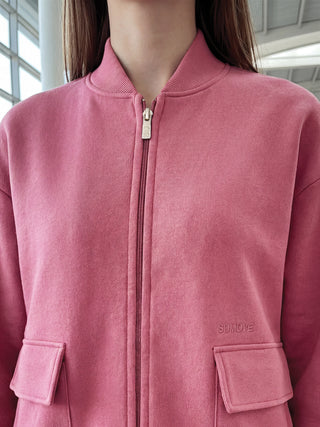 Women in a pink bomber jacket with a zipper closure and two front pockets.
