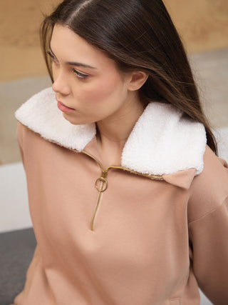 Women's tan quarter-zip fleece sweatshirt with a white sherpa collar and gold zipper detail.