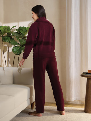 Women, standing, wearing a burgundy tracksuit.