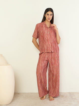 Woman posing in a red striped collared short-sleeve pajama set.