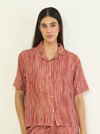 A woman poses in a red striped pajama set.