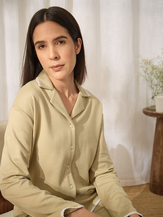 A woman in a pale yellow pajama set with white trim.