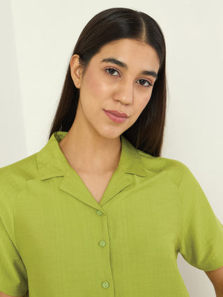 Women wearing a bright green collared, short-sleeved sleep shirt.