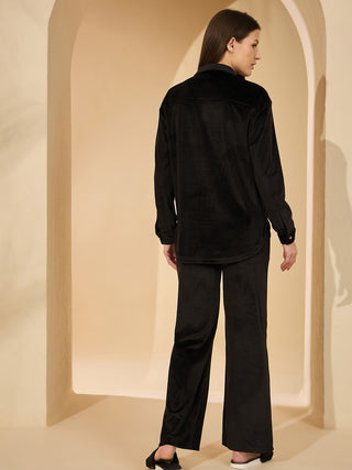 Women from the back, wearing a black corduroy pajama set.