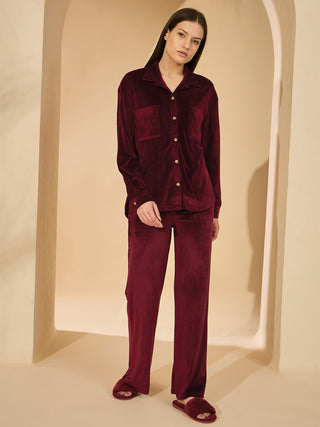 Women in maroon velvet pajama set, standing and looking at the camera.