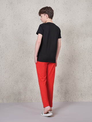 BOYS, back view of boy wearing black t-shirt and red sleep pants.