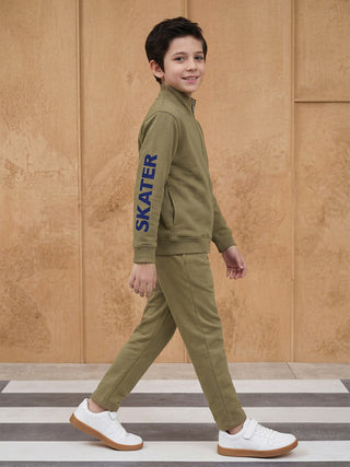 BOYS in a green tracksuit with "SKATER" print on the sleeve.