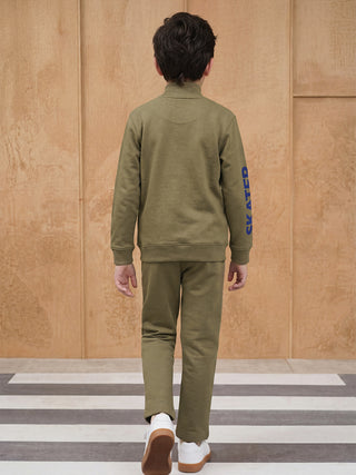 BOYS walking away from camera wearing a green loungewear set with "SKATED" printed on the sleeve.