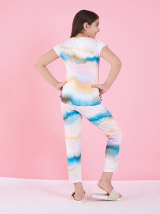 Girls' tie-dye printed pajama set in pastel colors, standing with hands on hips and facing away from the camera.