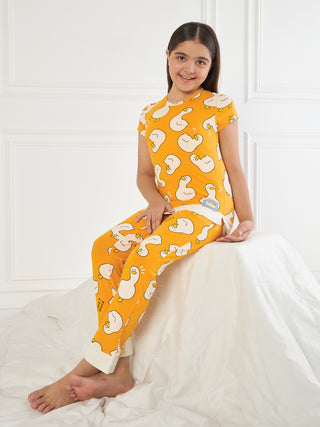 GIRLS orange short-sleeve top and pants pajama set with a white duck print, sitting on a white surface.