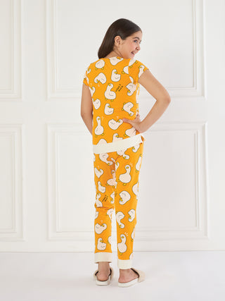 Girls, a full shot from the back, wearing orange pajamas with a white duck print.