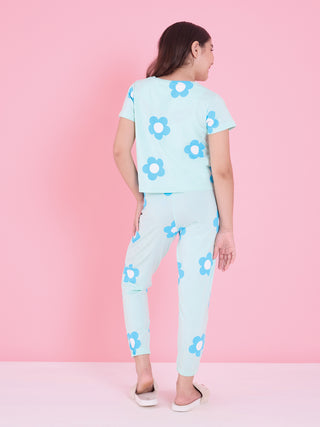 A young girl is shown from behind wearing a light blue pajama set with a white and blue flower print.