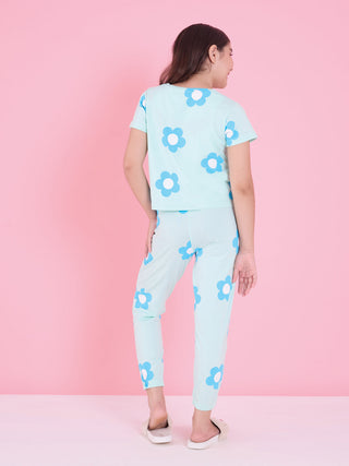 A young girl is shown from behind wearing a light blue pajama set with a white and blue flower print.