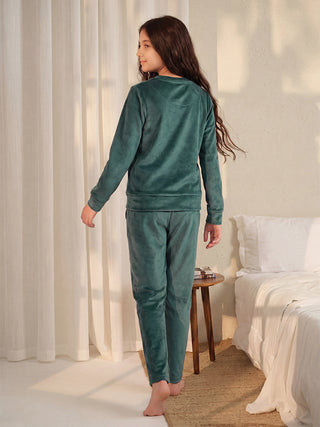 GIRLS green velvet pajama set, standing facing away from camera.