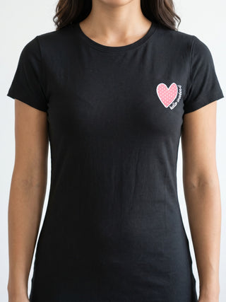 A woman wearing a black short-sleeve t-shirt with a pink polka dot heart print that says "hello sweetie".