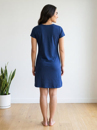 Women wearing a dark blue short-sleeve t-shirt dress, posing from behind with a neutral background.