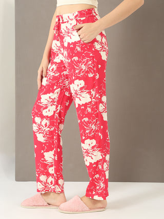 Women's red floral print pajama pants with a drawstring waist and pink slippers.