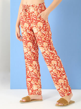 Women's rust-colored floral print lounge pants with a drawstring waist.